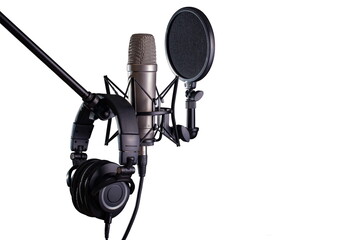 Studio condenser microphone with pop filter on stand with headphones on isolated on white background