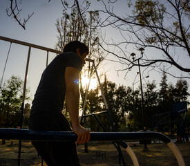 man doing exercise by sunset, backlighting