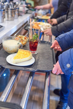 The queue at the checkout in the gastronomic cafe. Distribution line in the dining room. Trays with dishes move along metal rails from bain marie counter