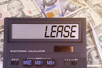 On the table are dollars and a calculator on the electronic board which says LEASE