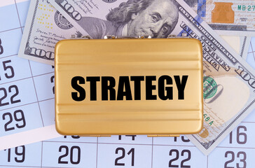 On the table lies a calendar, money and a briefcase with the inscription - STRATEGY