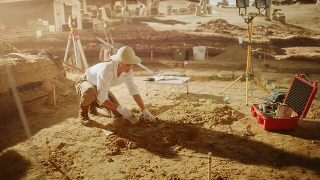Archaeological Digging Site: Great Female Archeologist Work on Excavation Site, Cleaning Cultural Artifacts with Brush and Tools. Discovery of Ancient Civilization Temple, Architecture, Fossil Remains