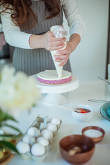 Young beautiful woman bakes a cake. Sweets. Confectionery.