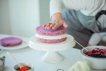 Fototapeta na wymiar Young beautiful woman bakes a cake. Sweets. Confectionery.