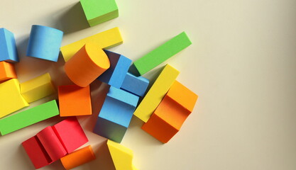 Childrens playing colored geometric shapes close-up top view on a light table selective focus.