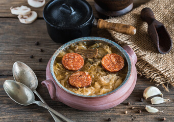 Christmas cabbage soup in ceramic bowl on natural wooden background.