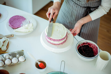 Young beautiful woman bakes a cake. Sweets. Confectionery.