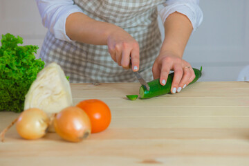 young woman cuts vegetables close-up in the kitchen. healthy eating and diet