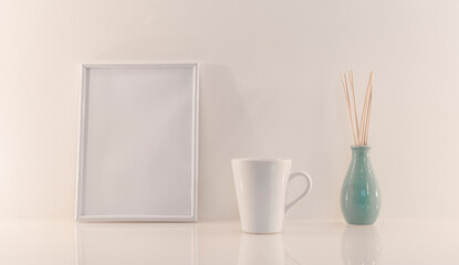 Modèle de cadre photo blanc avec espace vide pour logos, inscription publicitaire. Cadre en mode portrait sur un espace de travail avec une tasse à café.
