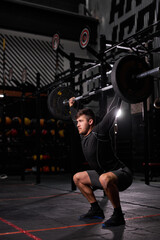 Fototapeta na wymiar fit muscular man with big muscles holding heavy weight for cross fit swing training hard core workout in the gym, wearing sportive clothes, alone. portrait