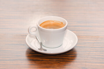white cup with hot coffee on the table