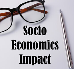 Glasses and pen with socio economics impact wording.