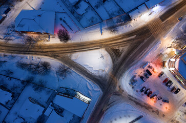 Traffic junction in a snowy night city from aerial top view.