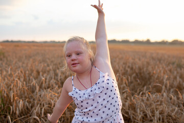 Naklejka na ściany i meble Girl with Down syndrome outdoors, soft focus