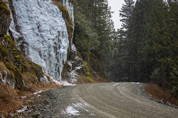 Fototapeta premium Large icicles on side of mountain along forestry road in February