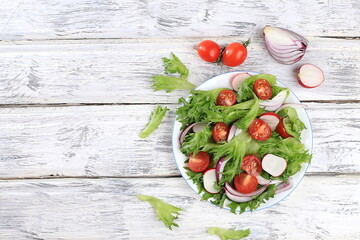 Vegetable salad with cucumber, cherry tomatoes, radish and fresh arugula, Healthy natural breakfast with lemon, detox diet concept, no cholesterol and GMO, selective focus,