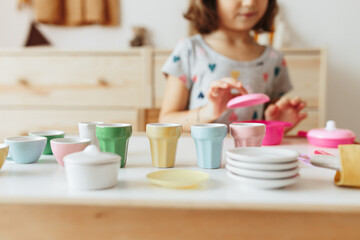 Little girl playing children tableware