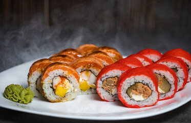 set of rolls on a white plate with wasabi and smoke