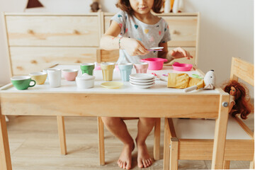 Little girl playing children tableware