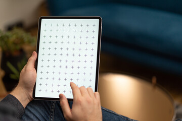 Young man reading e-book, news on tablet.