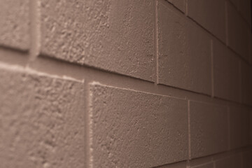 Decorating the wall with brick-shaped plaster. Beige wall, selective focus