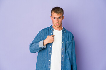 Young caucasian handsome man surprised pointing with finger, smiling broadly.