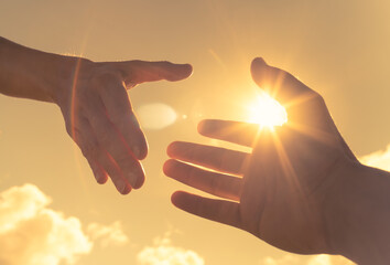 Giving a helping hand on sky background. Relief and support concept.  - obrazy, fototapety, plakaty
