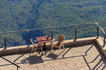 Table and chairs on a viewing platform for rest on a top of Tahtali mountain near Kemer, Antalya province in Turkey