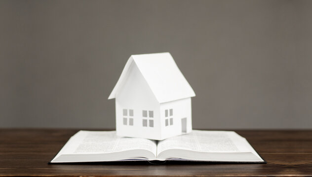 Open book. Holy Bible. Miniature model of the house. The concept of building your home on the Word of God