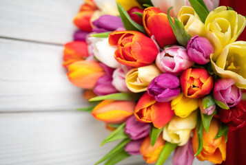 Colorful bouquet of tulips on white wooden background. Spring flowers. Greeting card with copy space for Valentine's Day, Woman's Day and Mother's Day.