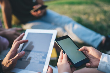 Friends text messages using gadgets in garden