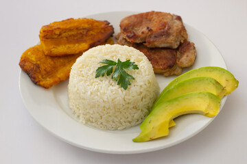 plato almuerzo dominicano, tostones fritos, arroz blanco acompañados de varios aguacates cortados, comida en casa, acercamiento, acercamiento