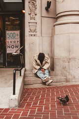 Homeless man sitting outside a luxury shopping mall, San Francisco, California, united States of...
