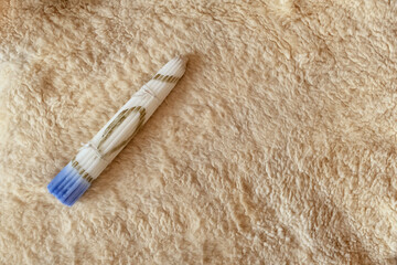 A white Easter candle consisting of 33 candles lies on a soft white woolen bedspread