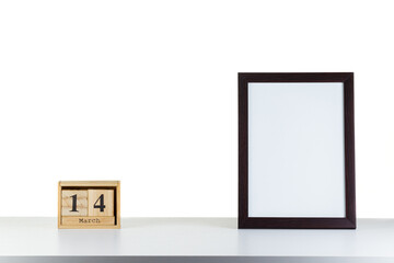Wooden calendar 14 march with frame for photo on white table and background