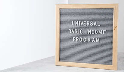 Letter board with words Universal Basic Income Program. Announcement government support program