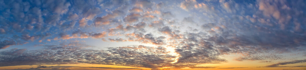 Naklejka na ściany i meble Dramatic clouds at sky at sunset .