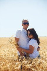 young love couple in white t-shirts a guy and a girl hugging in a yellow gold wheat field