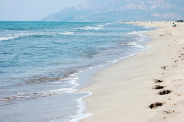 Sandy beach and blue sea waves. Beautiful nature background.