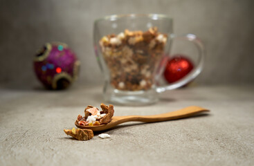 Fruit tea in wooden spoon and cup full of it in the background. 