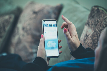 a middle-aged woman is lying in bed reading messages on a cell phone