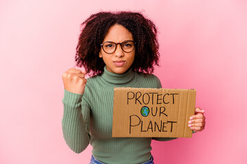 Young african american mixed race woman holding an protect our planet cardboard showing fist to...