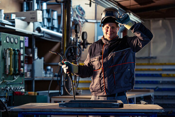 Portrait of a smiling welder posing in the factory