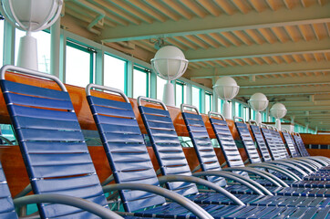 Outdoor pool deck with sun loungers and deck chairs on modern cruiseship or cruise ship liner