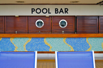 Pool bar counter and sun loungers deck chairs on outdoor deck of modern cruiseship or cruise ship...