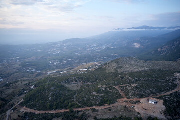 Mountain village on a cloudy day. Aerial view of hiking trails in the mountains. Picturesque morning scene.