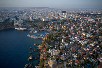 Aerial drone view of resort town on the seashore. Landscape view of coastal town with sea, harbor, boats and buildings.