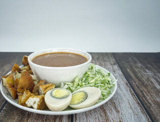 Indian Rojak with fried shrimp fritters, tofu, egg, shredded cucumber and turnip with sweet and spicy peanut gravy. Popular street food in Malaysia. Selective focus points. Blurred background