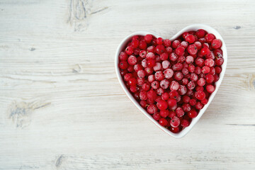 frozen red currants on wooden surface