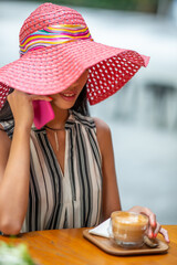 Beautiful asian girl having breakfast at the table looking at the smartphone